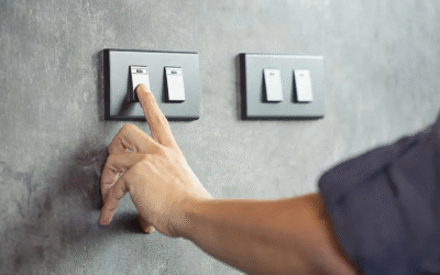 How High Should a Light Switch Be? Simple Rules for Your Home Hand reaching to turn on a modern black light switch installed on a gray wall at standard height